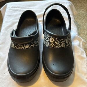 Black clogs with floral patterns